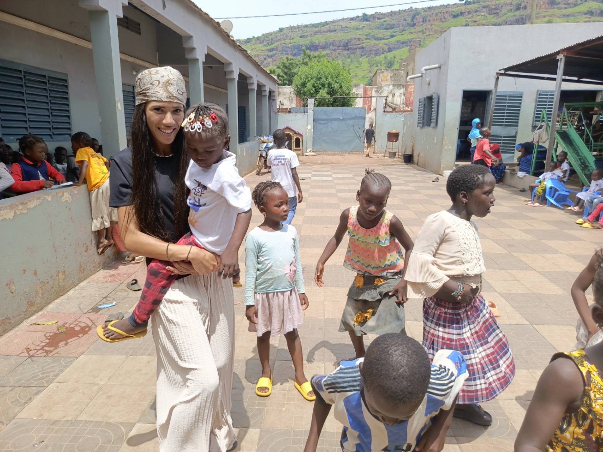 Bénévole de l'AMET portant une enfant à l'orphelinat NIABER de Sébénicoro